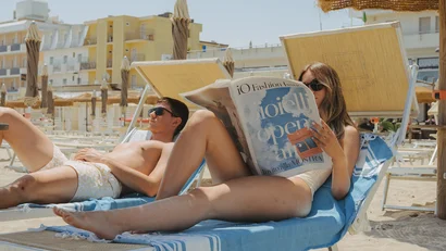 Coppia che si rilassa su lettini da spiaggia sotto ombrelloni