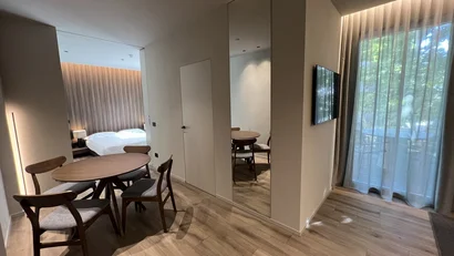 Sala da pranzo moderna con tavolo rotondo, quattro sedie e vista camera da letto