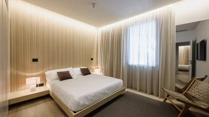 Camera da letto moderna con letto matrimoniale, lampade e sedia in legno