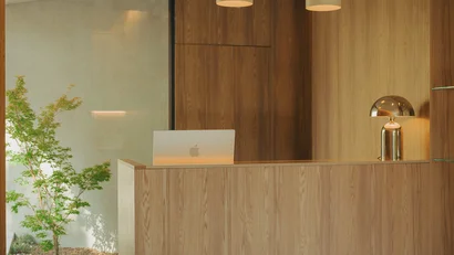 Reception moderna in legno con lampada e computer vicino a una finestra grande