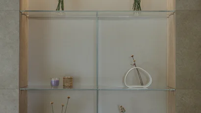 Mensola in vetro con vasi di fiori e decorazioni minimaliste