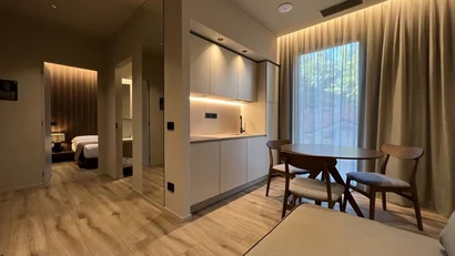 Interno moderno con angolo cottura, tavolo da pranzo e camera da letto visibile