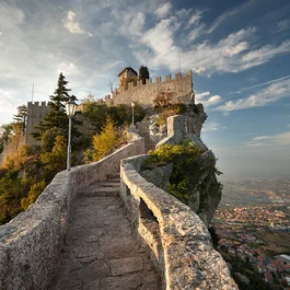 Mura medievali e strada lastricata su una collina con vista sulla città