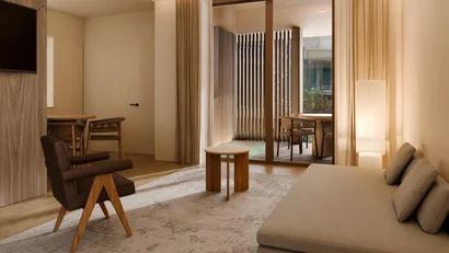 Soggiorno moderno con divano, sedia in pelle e tavolino davanti a porte scorrevoli