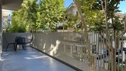 Balcone con tavolo e sedie, vista su alberi e case vicine