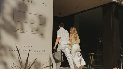 Coppia che entra in un edificio moderno con scritta palace suite apartments