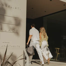 Coppia che entra in un edificio moderno con scritta palace suite apartments