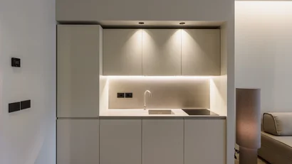 Cucina moderna minimalista con armadietti beige e illuminazione a LED