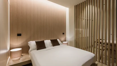 Camera da letto moderna con letto matrimoniale e parete divisoria in legno
