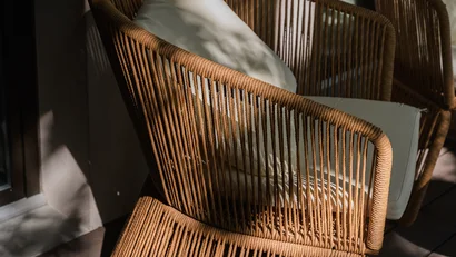 Sedia di vimini con cuscino bianco in luce naturale