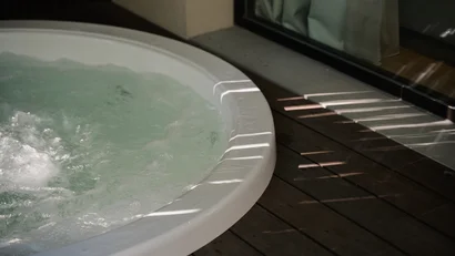 Vasca idromassaggio con acqua che bolle su pavimento in legno