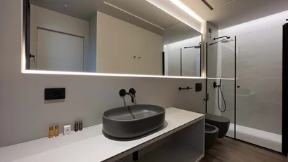 Bagno moderno con lavabo ovale grigio e specchio illuminato a LED