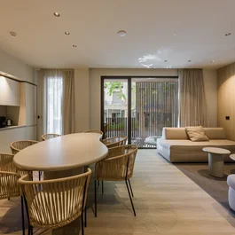 Soggiorno moderno con tavolo, sedie in legno e divano beige