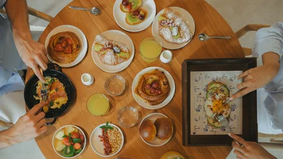 Colazione con frutta, dolci, succo d'arancia e uova su tavolo rotondo