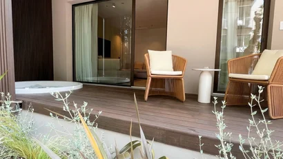 Veranda moderna con sedie in vimini e una vasca idromassaggio