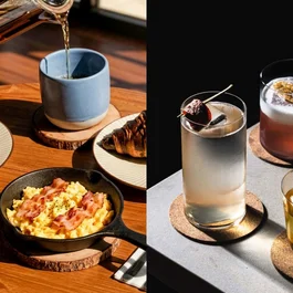 Colazione con caffè, uova strapazzate, cornetto e cocktail su tavolo di legno