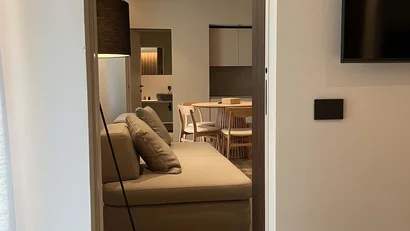 Interno moderno con divano beige, lampada a terra e sala da pranzo