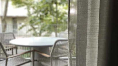 Tavolo bianco e sedie su una terrazza con alberi verdi sullo sfondo